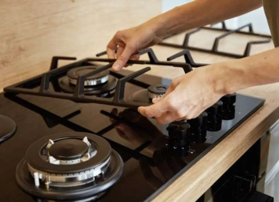Technician fixing gas hob burner in Chennai home kitchen